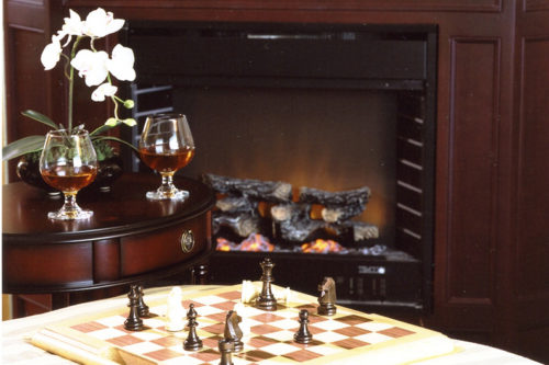 Table with chessboard and two glasses of brandy