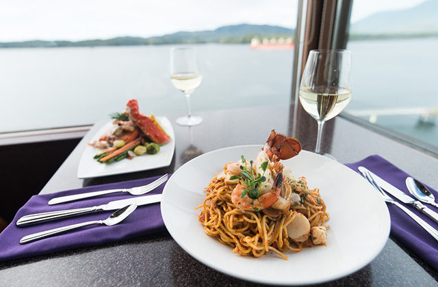 Two plates of food on lakeside table