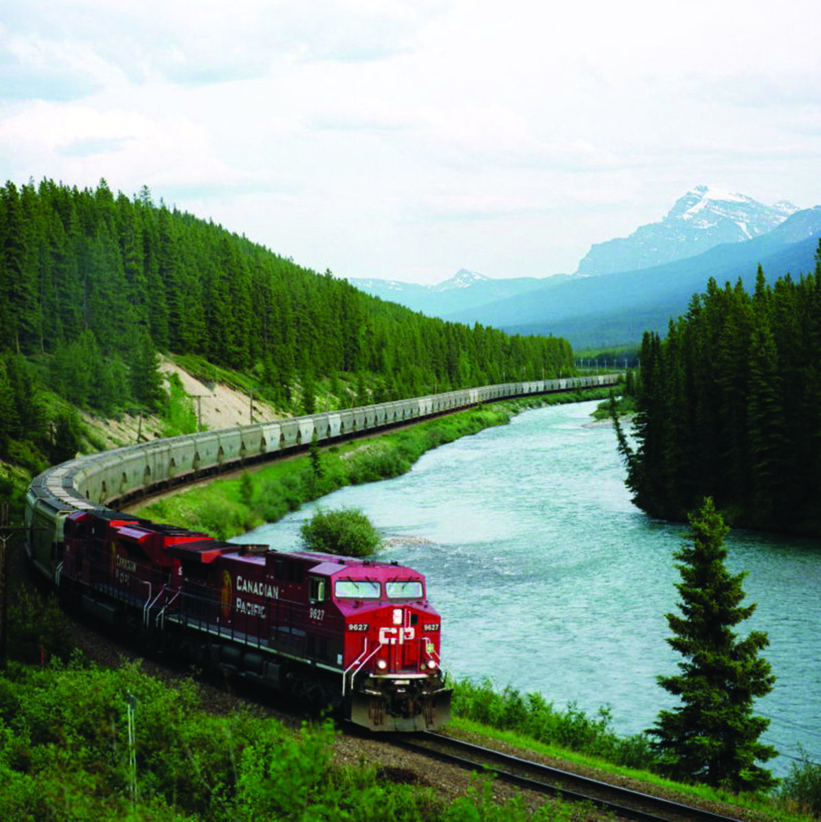 Train chugging past a mountain lake