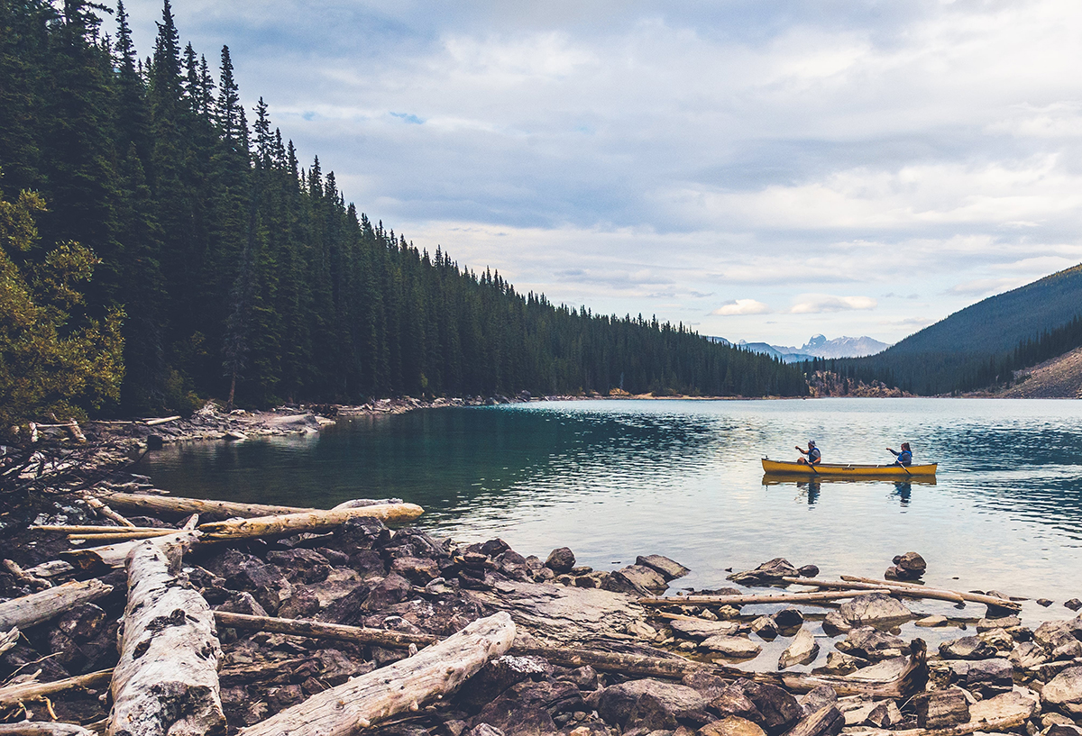 Two people in a yellow canoe on mountain lake