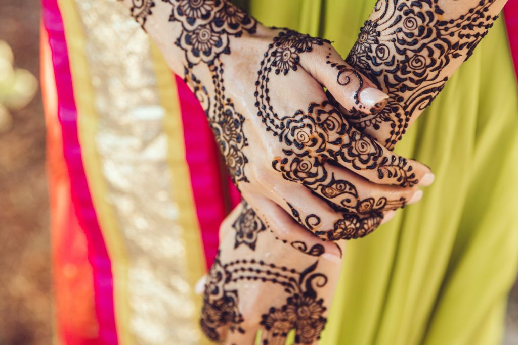 woman in colorful sari with henna painted hands